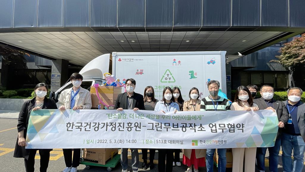 탄소절감, 더 나은 세상을 우리 어린이들에게 : 한국건강가정진흥원-그린무브공작소 업무협약 플랜카드를 든 참가자들