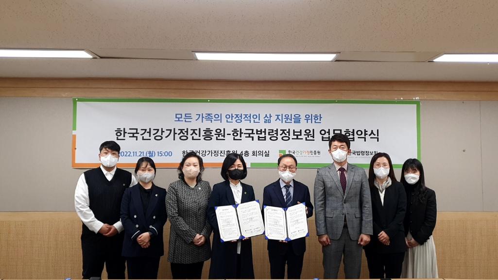 모든 가족의 안정적인 삶 지원을 위한 한국건강가정진흥원-한국법령정보원 업무협약식 플랜카드 앞에서 단체사진 촬영